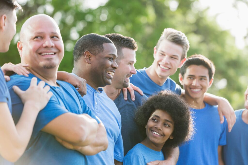 Multi-ethnic group of men and sons in blue shirts